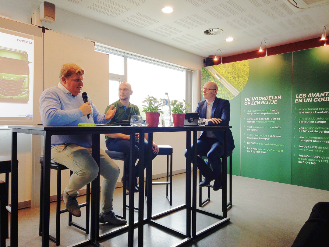 Chief Finance Officer de chez Jost assis à une table haute parlant au micro avec deux intervenants.